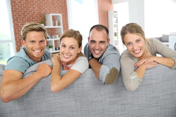 Colegas de quarto alegres sentados no sofá — Fotografia de Stock