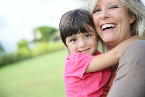 Woman embracing little girl in arms Stock Image