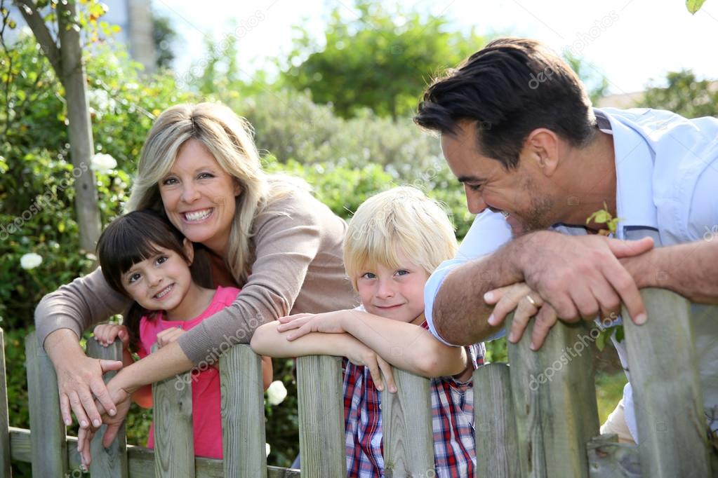 Family leaning on fence