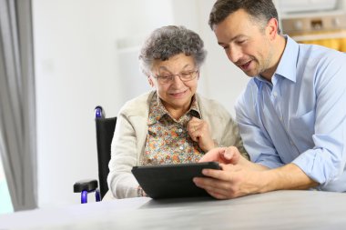 Adamla yaşlı kadın tablet kullanma
