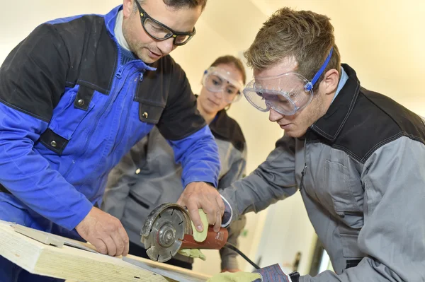 Estudiantes aprendiendo a usar la sierra — Foto de Stock