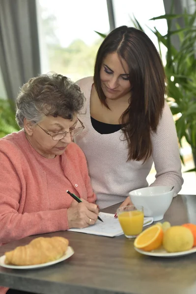 Elderly woman doing crossword — Stock Photo, Image