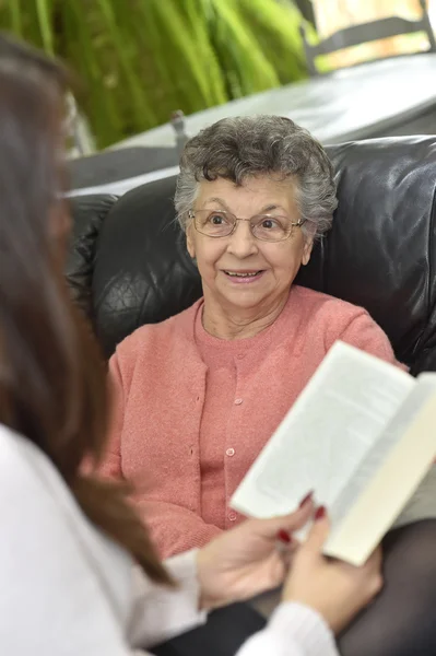 Home carer livro de leitura para a mulher — Fotografia de Stock