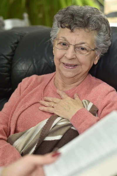 Home carer reading book to woman — Stock Photo, Image