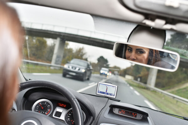 Woman looking at rear view mirror