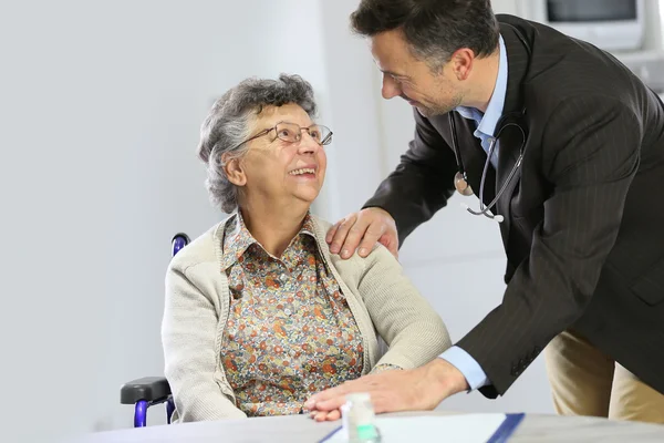 Médico tranquilizando a la anciana — Foto de Stock