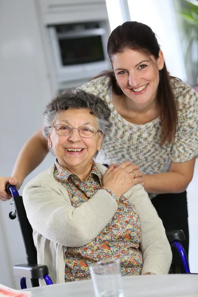 Femme en fauteuil roulant avec soignant à domicile — Photo