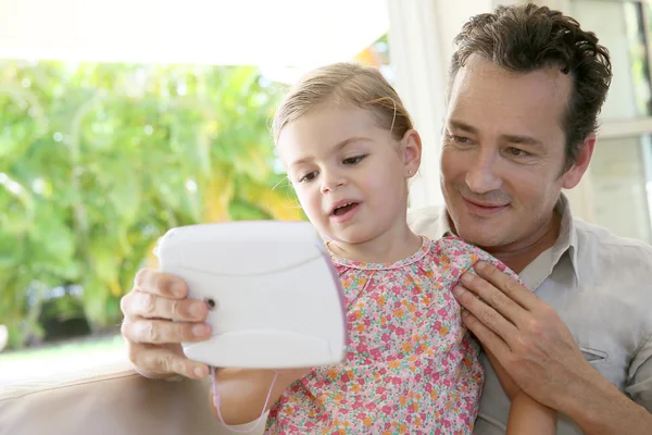 Man med dotter spelar med tablett — Stockfoto