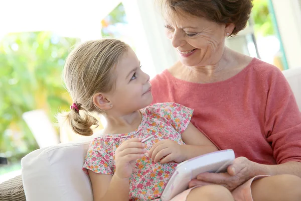 Flicka och mormor med barn tablett — Stockfoto