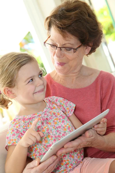 Dziewczyna z babcia grając na tabletki — Zdjęcie stockowe