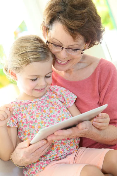 Dziewczyna z babcia grając na tabletki — Zdjęcie stockowe