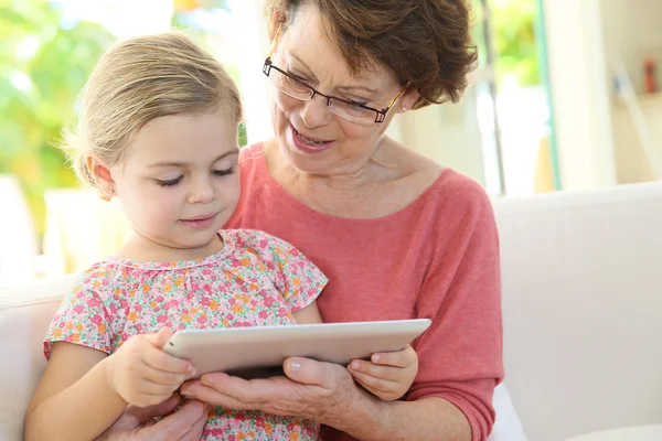 Menina com avó jogando no tablet — Fotografia de Stock