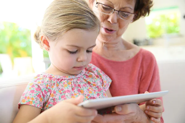 Gadis dengan nenek bermain di tablet — Stok Foto