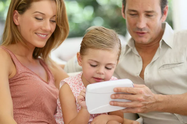 Los padres con niña jugando con la tableta —  Fotos de Stock