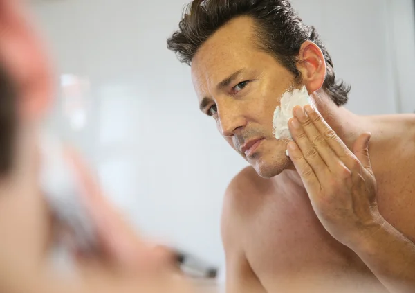 Mann rasiert sich vor Spiegel — Stockfoto