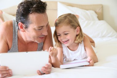 Adam akıllı telefon ve kızı tablet ile