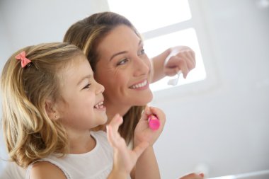 Mother and daughter in bathroom clipart