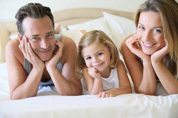 Família deitada na cama — Fotografia de Stock