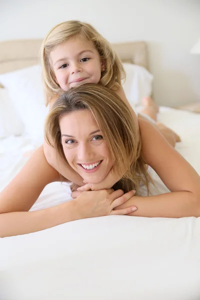 Ragazza con mamma posa sul letto — Foto Stock