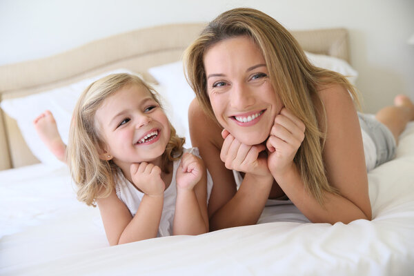 Girl with mommy laying on bed