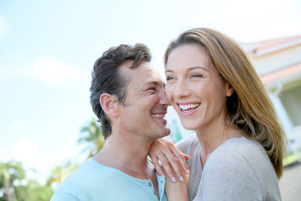 Couple standing in front of home
