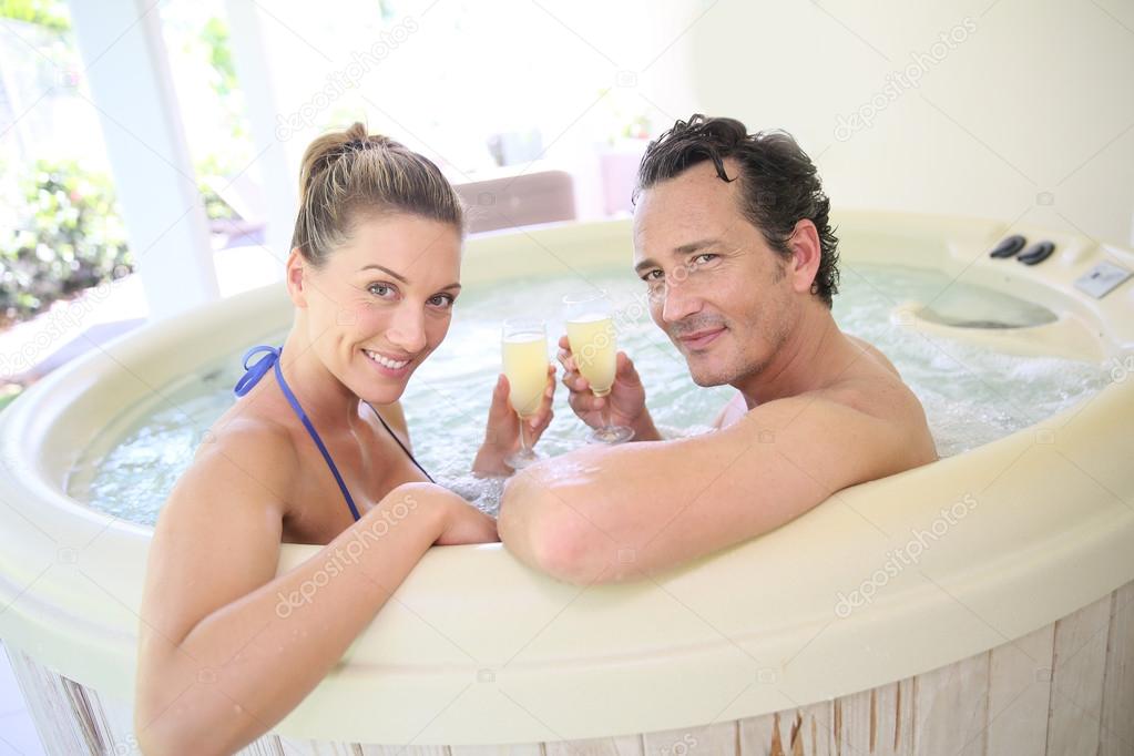 Couple drinking cahmpagne in tub