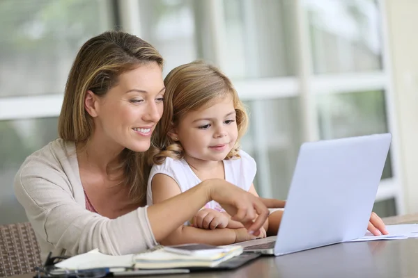 Девушка смотрит на ноутбук с матерью — стоковое фото