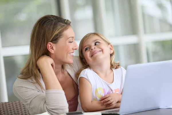 Дівчина дивиться на ноутбук з матір'ю — стокове фото