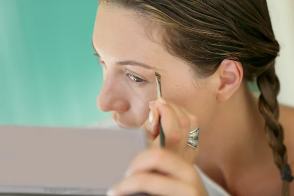 Mujer aplicando maquillaje — Foto de Stock