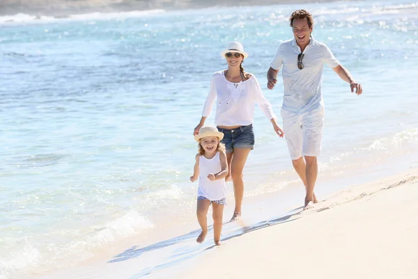 Couple with girl running on beach — Stock Photo, Image