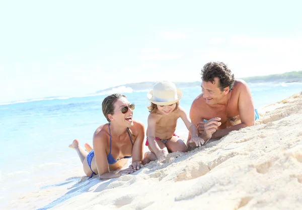 Family laying on sandy beach — Stock Photo, Image