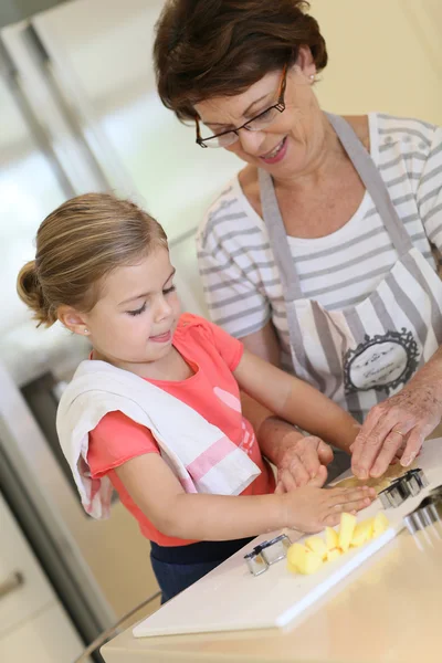 Nonna con biscotti ragazza cottura — Foto Stock