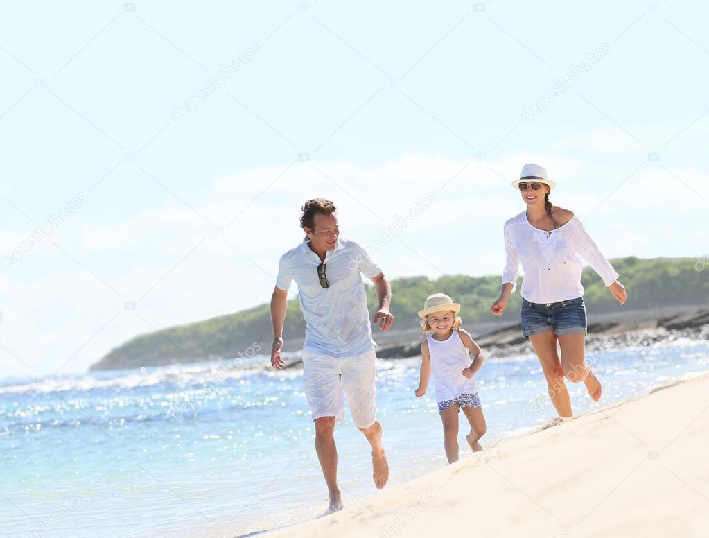 Couple with girl running on beach
