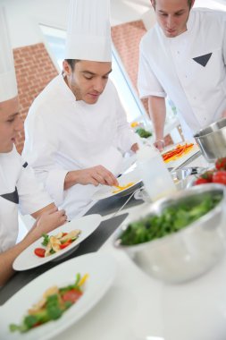 Chef training students in kitchen clipart