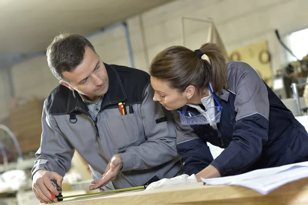 Travailleurs mesurant la planche de bois — Photo