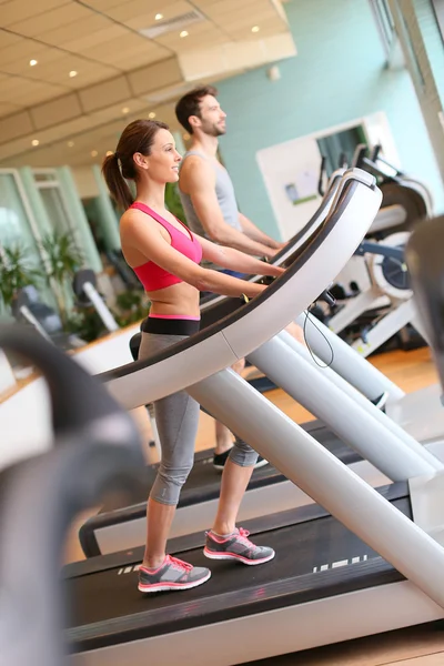 Pareja haciendo ejercicio en la máquina cardiovascular —  Fotos de Stock