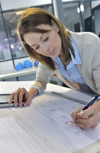 Woman engineer working on blueprint — Stock Photo, Image