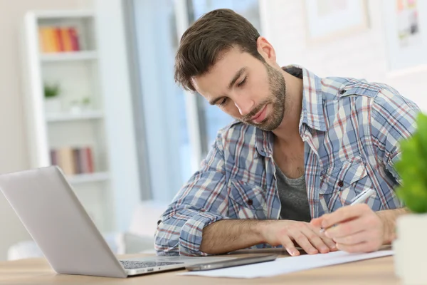 Arbeiter macht sich Notizen auf Papier — Stockfoto