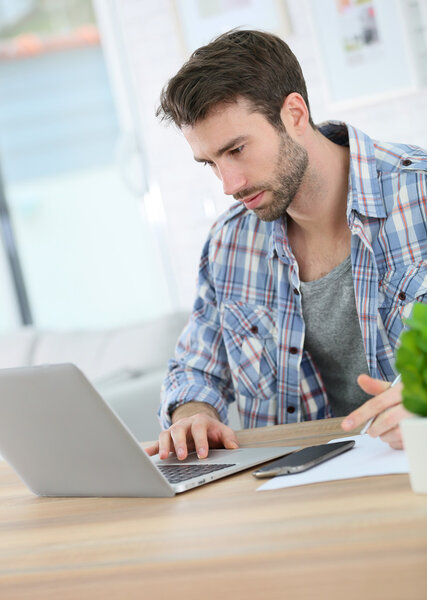 Businessman at home working on laptop