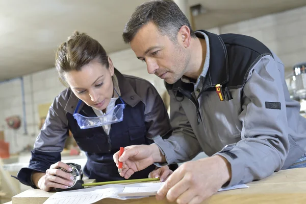 Arbeiter messen Holzplanken — Stockfoto