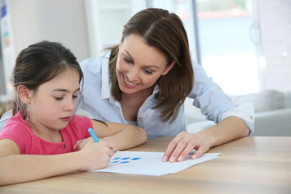 Menina com a mãe aprendendo a escrever — Fotografia de Stock