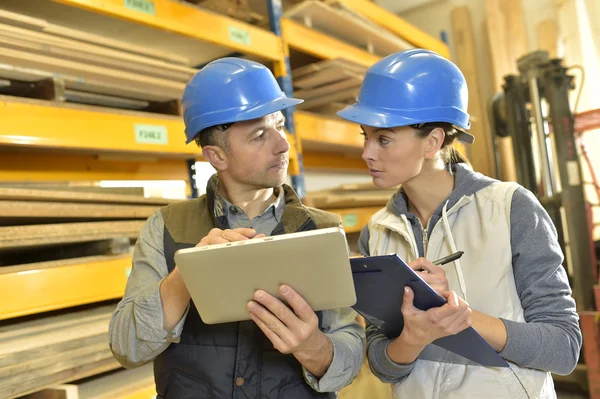 Trabajador con supervisor que controla el stock — Foto de Stock