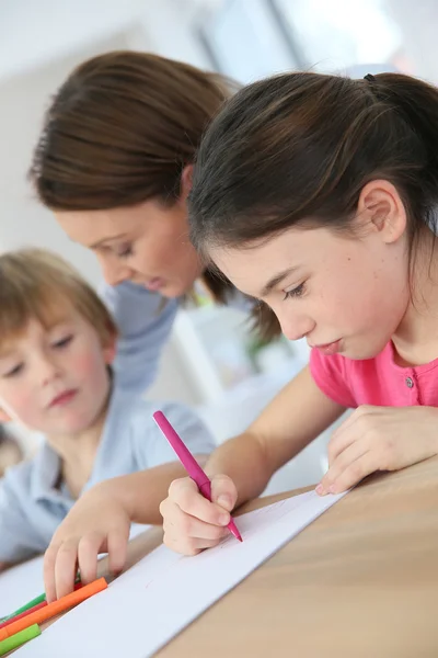 Mutter sieht Kindern beim Zeichnen zu — Stockfoto