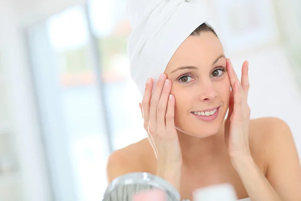 Mujer aplicando crema hidratante —  Fotos de Stock