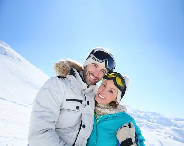 Pareja de esquiadores en pista de esquí — Foto de Stock