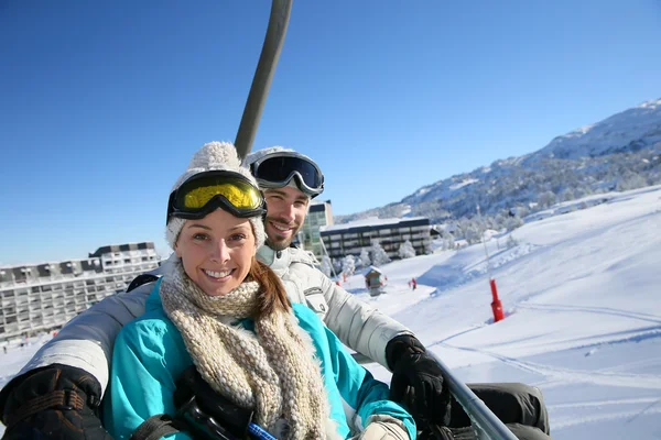 Couple on ski resort chairlift — Stock Photo, Image