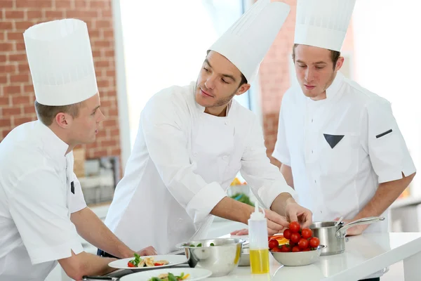 Кухар навчає студентів на кухні — стокове фото