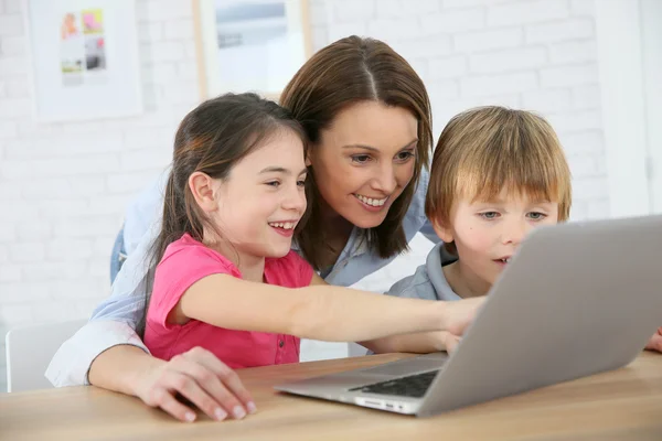 Moeder met kinderen spelen op laptop — Stockfoto