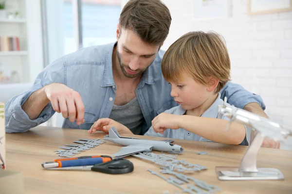 Father and son assembling airplane mock-up — Stock Photo, Image