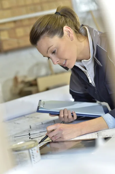 Vrouwelijke architect werken met blauwdruk — Stockfoto